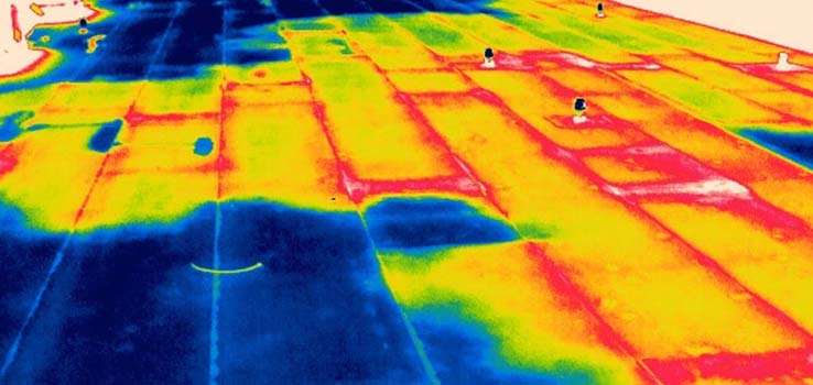 Post-sunset infrared thermographic scan of the low-slope roof at 2105 Mt Vernon Ave, showing warm areas of retained subsurface moisture against cooler dry sections of the modified bitumen assembly
