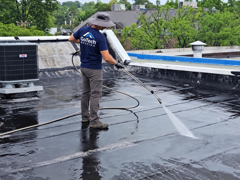 GoTech Roofing technician power washing the modified bitumen roof membrane at 2105 Mt Vernon Ave ahead of the silicone coating