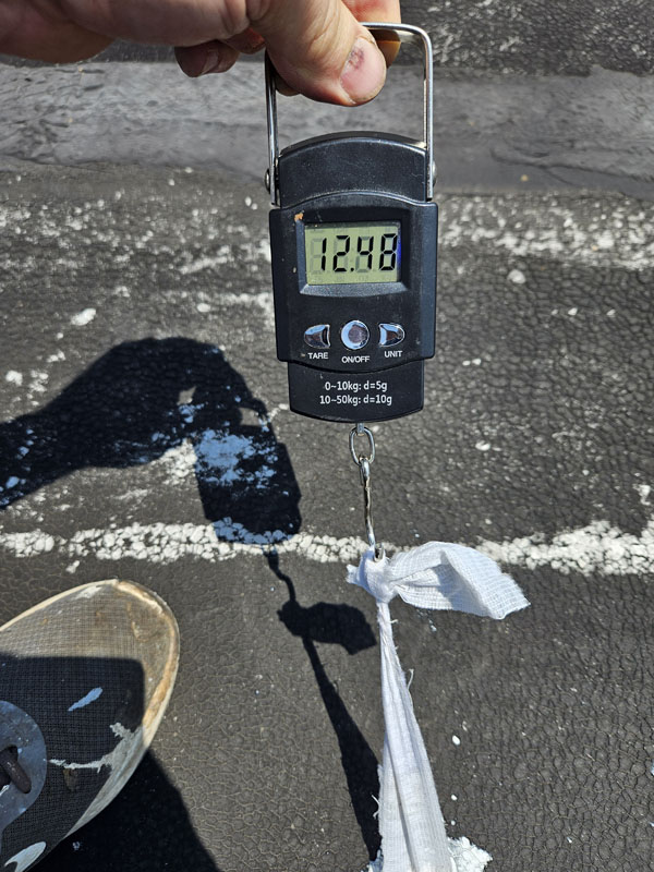 Adhesion pull test at 2105 Mt Vernon Ave using a spring gauge to peel a cured silicone and polyester fabric test strip from the cleaned modified bitumen surface