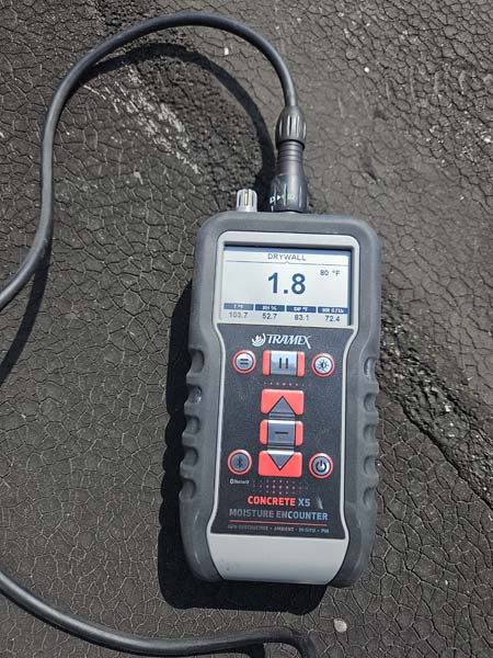 Tramex CMEX5 digital moisture meter taking a reading on the alligatored modified bitumen roof at 2330 Columbia Pike