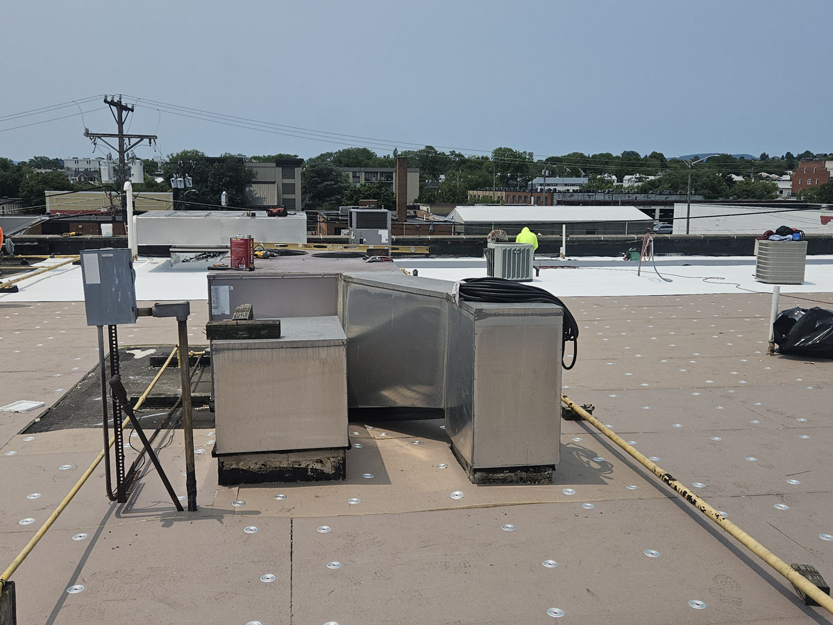 Crew rebuilding a rooftop HVAC curb on Roof 1 at 150 E Wolfe St during the TPO roof replacement