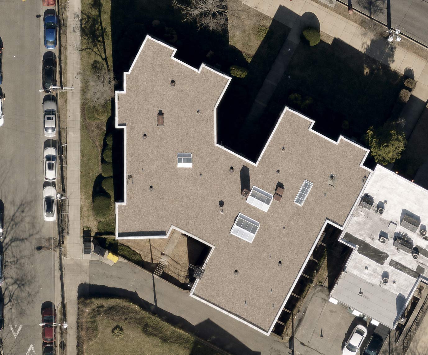 Overhead drone view of the completed ballasted TPO roof at 2801 Pennsylvania Ave SE, Washington DC, with new parapet coping and restored skylights