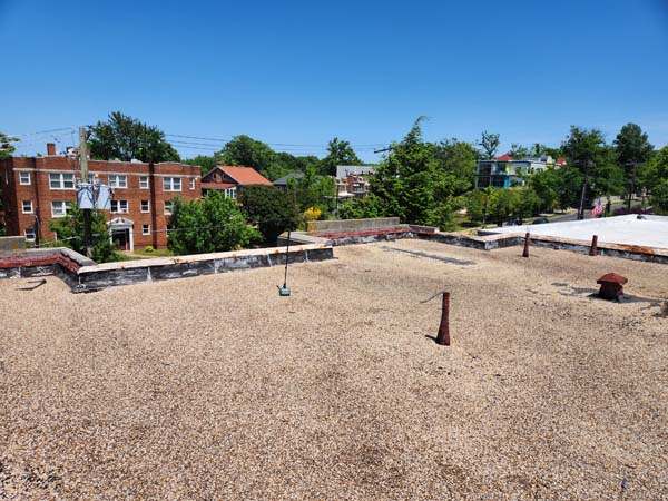 Wide view of the ballasted modified bitumen roof and parapet walls at 2801 Pennsylvania Ave SE before the replacement began