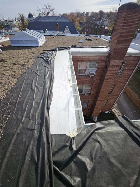 New white TPO membrane run in along the rebuilt gutter line at 2801 Pennsylvania Ave SE with the roof field still to be covered