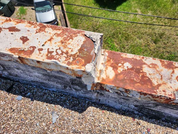 Parapet coping at 2801 Pennsylvania Ave SE rusted through with a split open joint above the ballasted roof