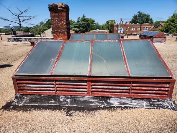 Deteriorated skylight with a corroded painted frame and wire-reinforced glazing on the ballasted roof at 2801 Pennsylvania Ave SE