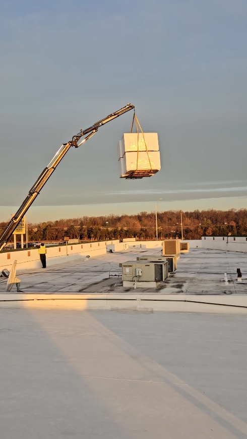 Roofing materials being craned to the roof at 7171 New Market Ct in Manassas, Virginia