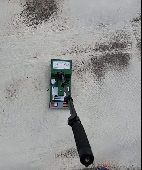 Tramex moisture meter recording a non-destructive moisture reading on the existing roof assembly at 7171 New Market Ct